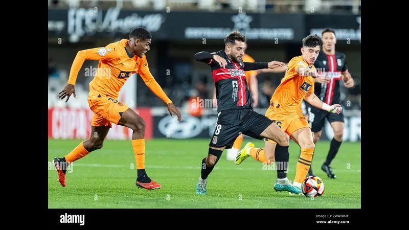 Cầu thủ Cartagena chống chế đội Valencia trong trận đấu bóng đá